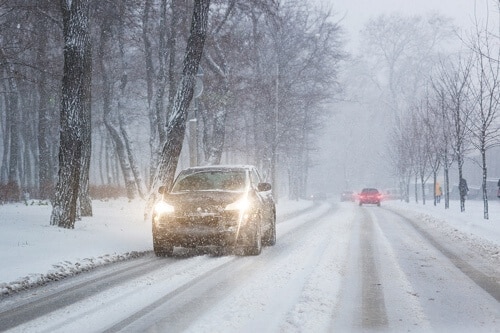 Safe winter driving tips for driving in Amagansett, Ny from Bock Auto: cars driving in wintry conditions with lights on