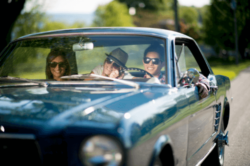How to Best Spend Your Winter Downtime to Prepare Your Classic Car for Spring in the Hamptons, NY with Bock Auto. Image of 3 young adults driving blue classic car in spring time