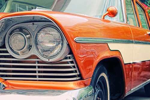 Closeup of old car with orange colored paint on automobile show | Bock Auto