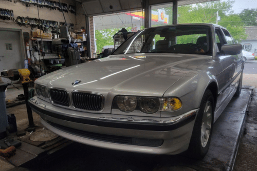 Car maintenance check in Amagansett, NY at Bock Auto. Image of silver 2001 BMW 740i undergoing car maintenance checks in Bock Auto garage for a road trip checklist.